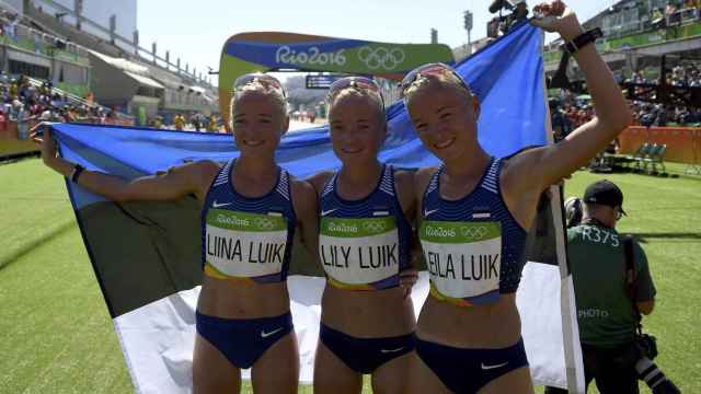 Liina, Lili y Leila Luik, posan con la bandera de Estonia después de la maratón.