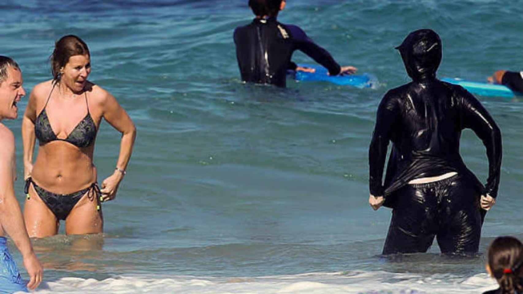 Una mujer con un burkini en una playa.