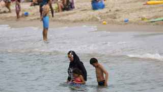 A Muslim woman wears a burkini, a swimsuit that leaves only the face, hands and feet exposed, on a beach in Marseille