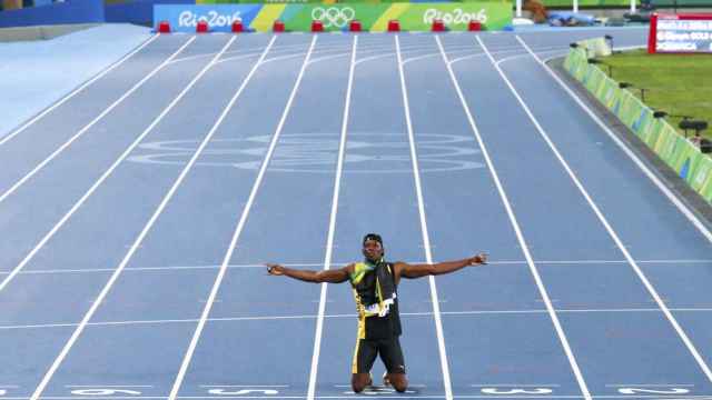 Usain Bolt, arrodillado sobre el tartán del Estadio Olímpico de Engenhao.