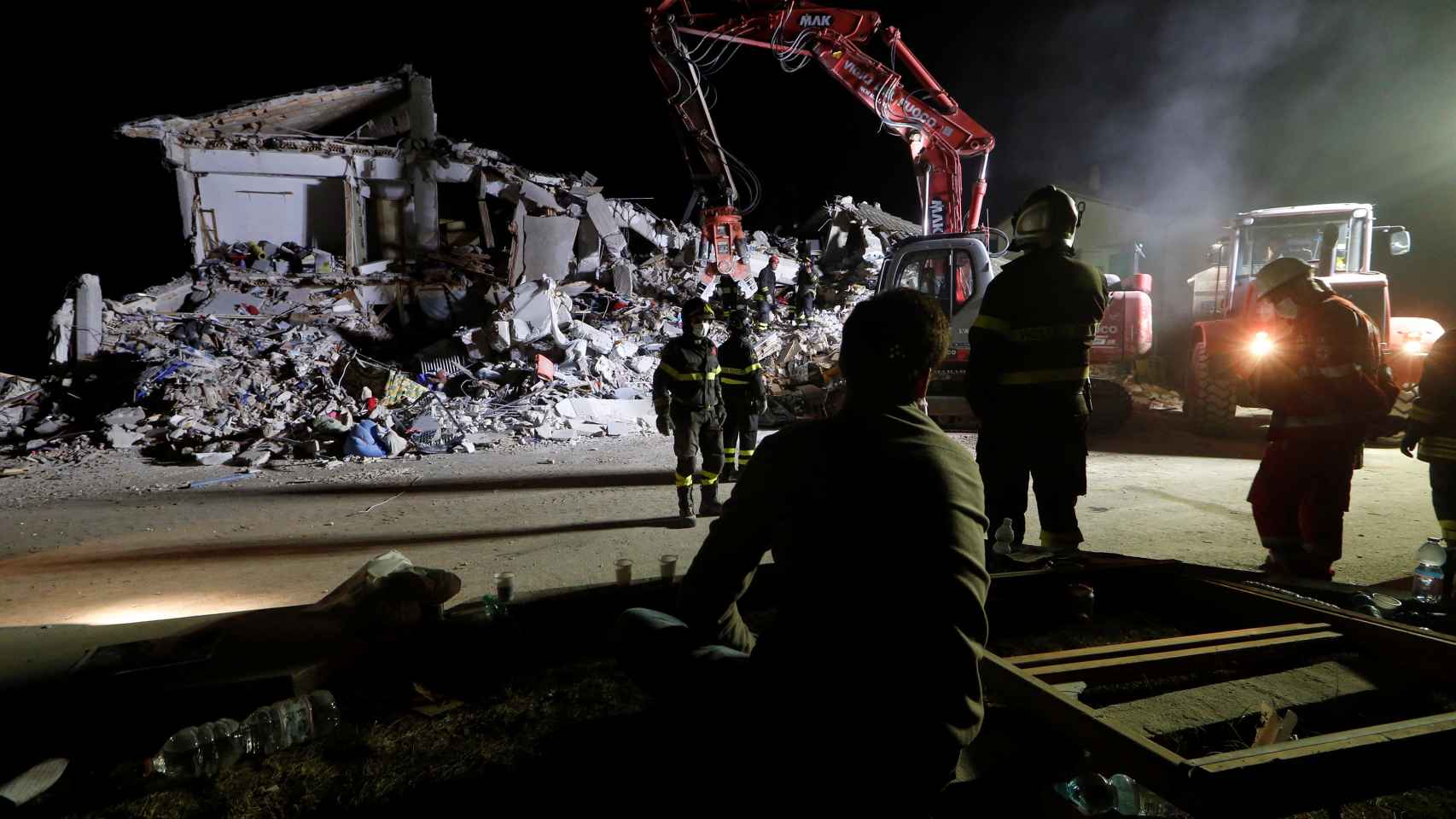Los bomberos trabajan durante la noche en Amatrice levantando escombros.