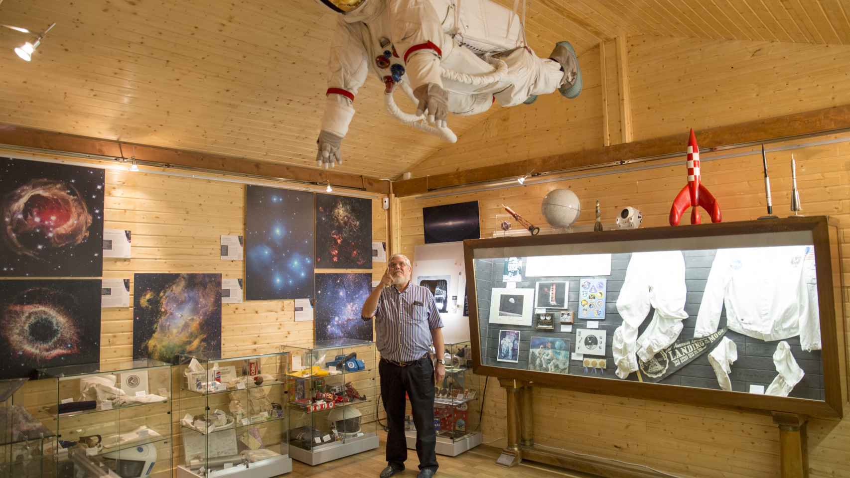 El ingeniero  señala un traje espacial colgado en el techo del museo.