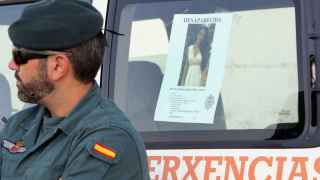 Un efectivo de la Guardia Civil junto a la imagen de Diana Quer