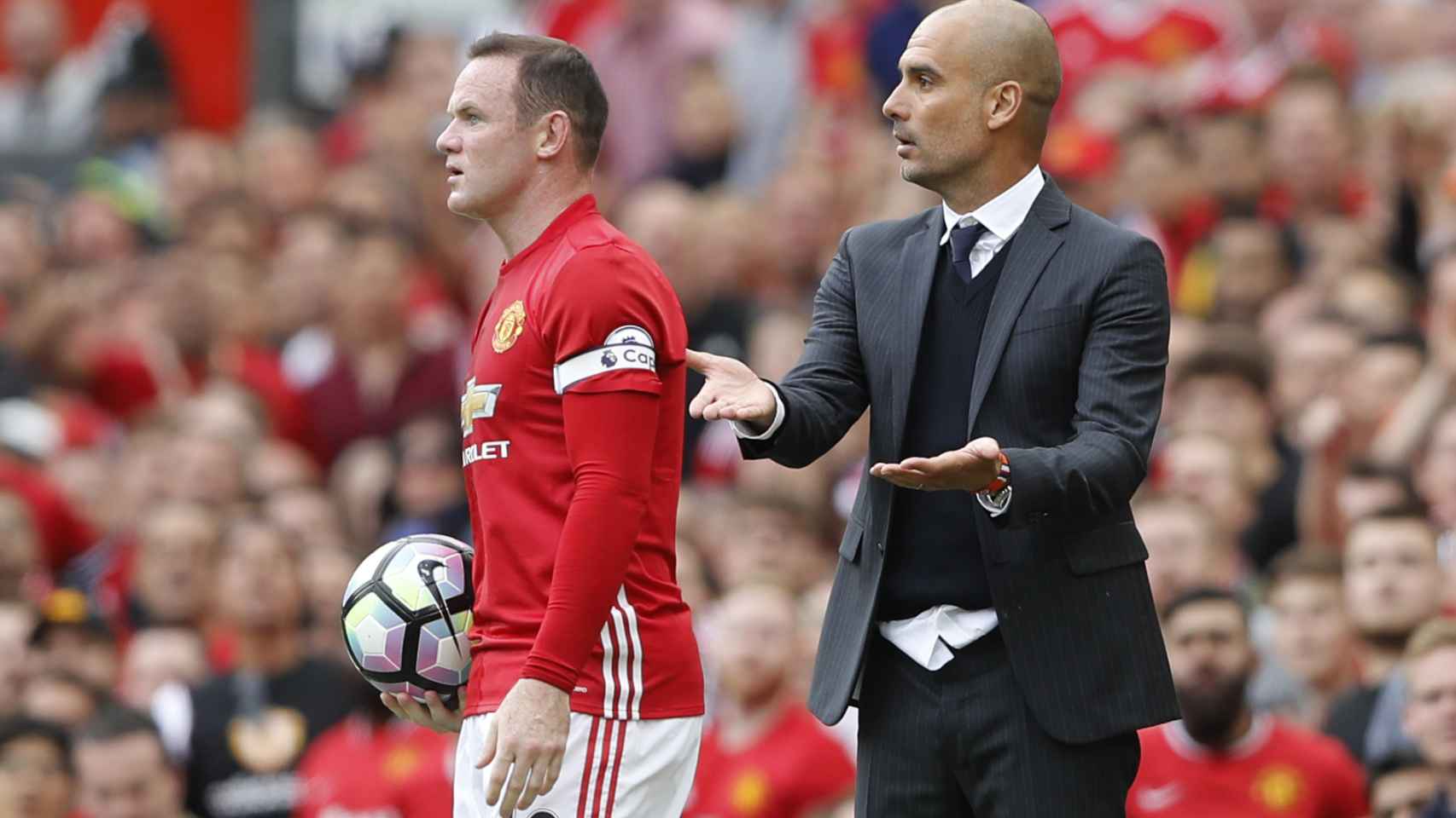 Pep Guardiola y Wayne Rooney en un United - City.