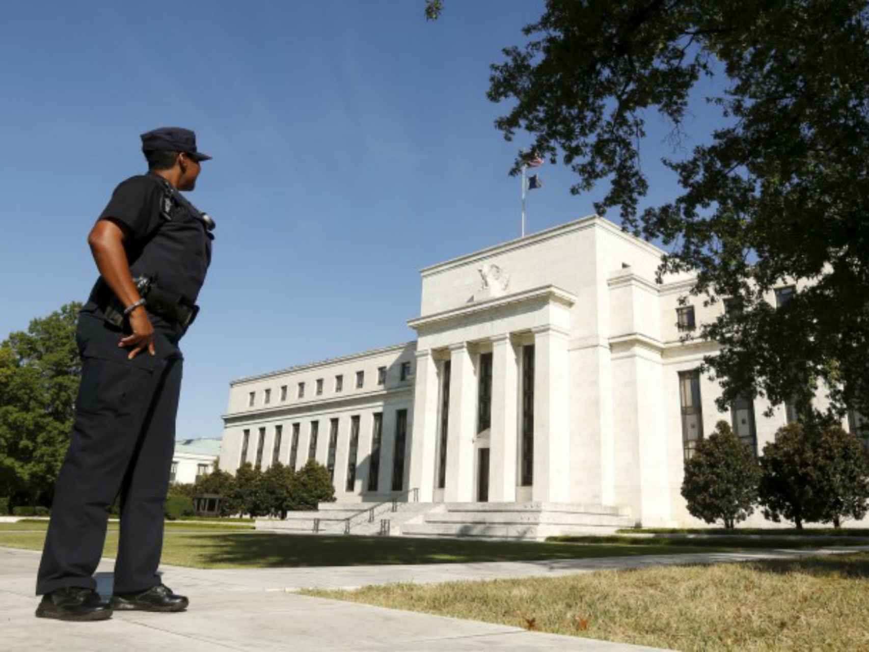 Una vigilante observa la sede de la Reserva Federal de EEUU.