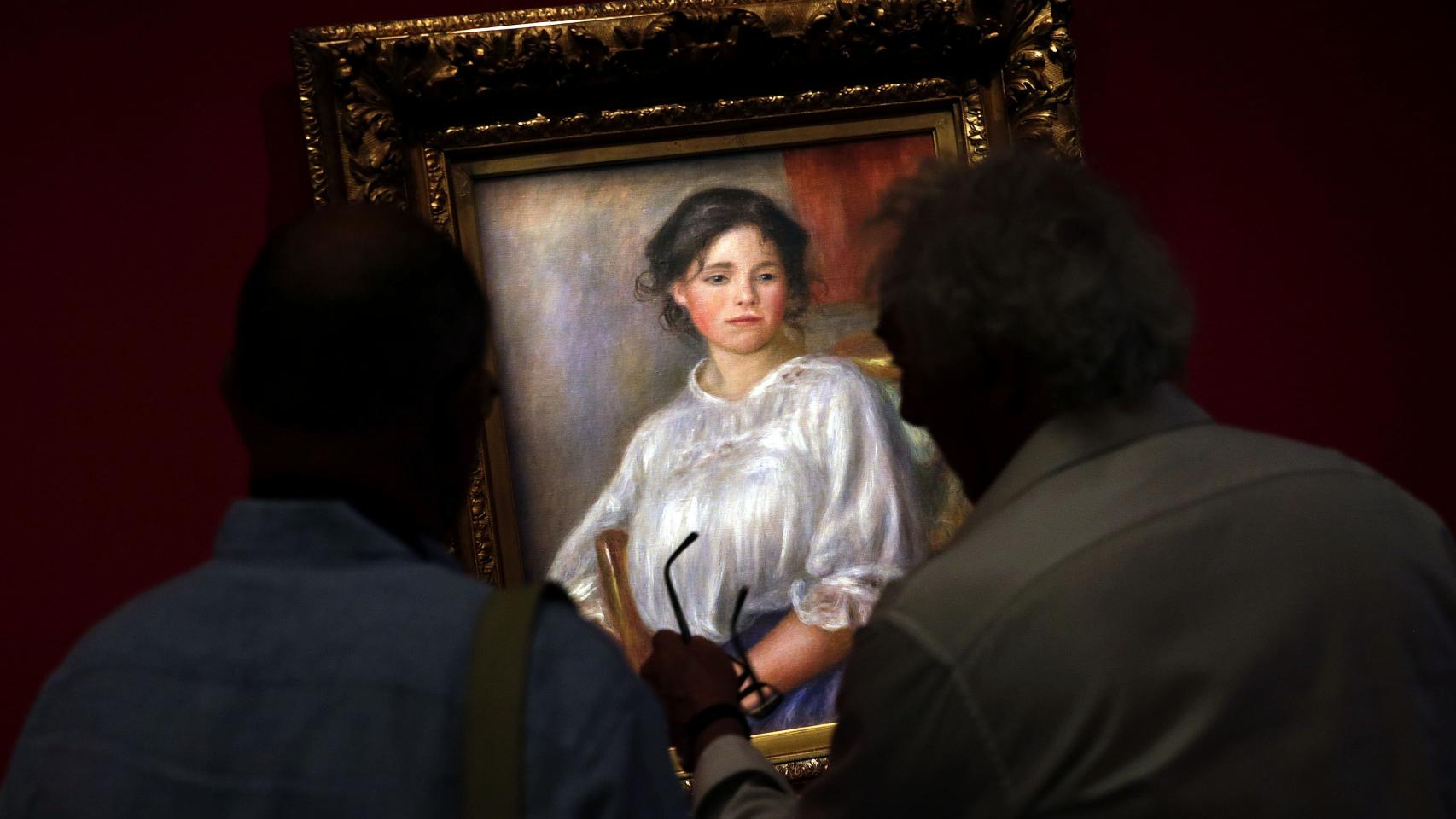 Dos hombres observan la obra Jeune fille assise (1909), de Auguste Renoir.