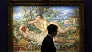 Un vigilante pasa ante la obra Les baigneuses (1919), de Auguste Renoir, que se muestra en la exposición.