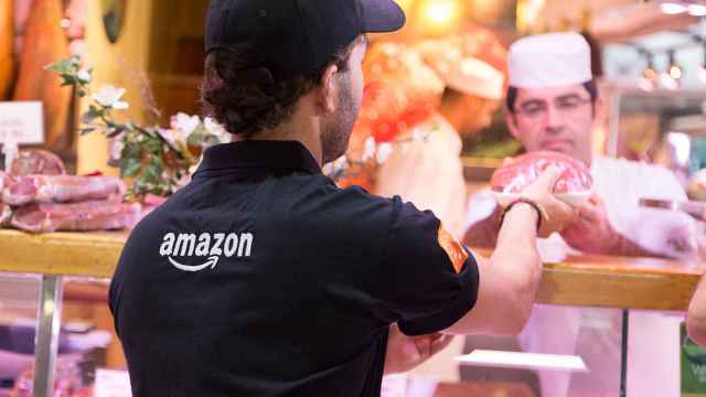 Un repartidor de Amazon recoge un producto en el Mercado de la Paz para su servicio 'Prime Now'.
