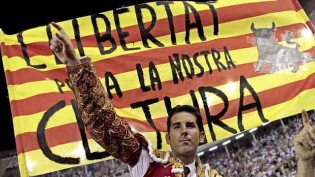 El torero Serafín Marín saluda a los asistentes a una corrida con una bandera catalana detrás.