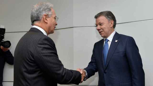 El expresidente Álvaro Uribe (izda.) estrecha la mano del presidente Juan Manuel Santos.