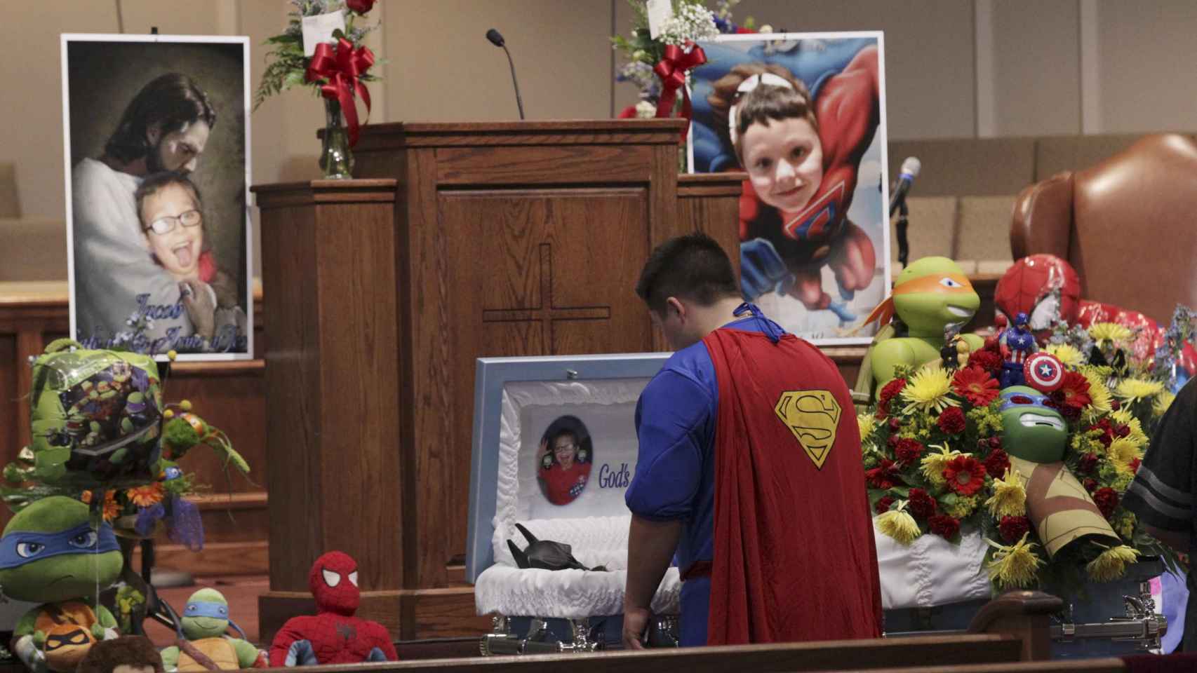 Superman, frente al féretro de Jacob, que murió tras un tiroteo en su escuela. | Reuters