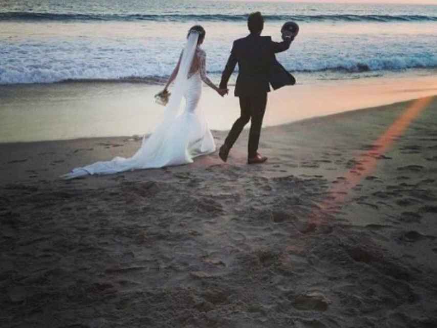 Los novios pasean por la playa ya convertidos en marido y mujer.