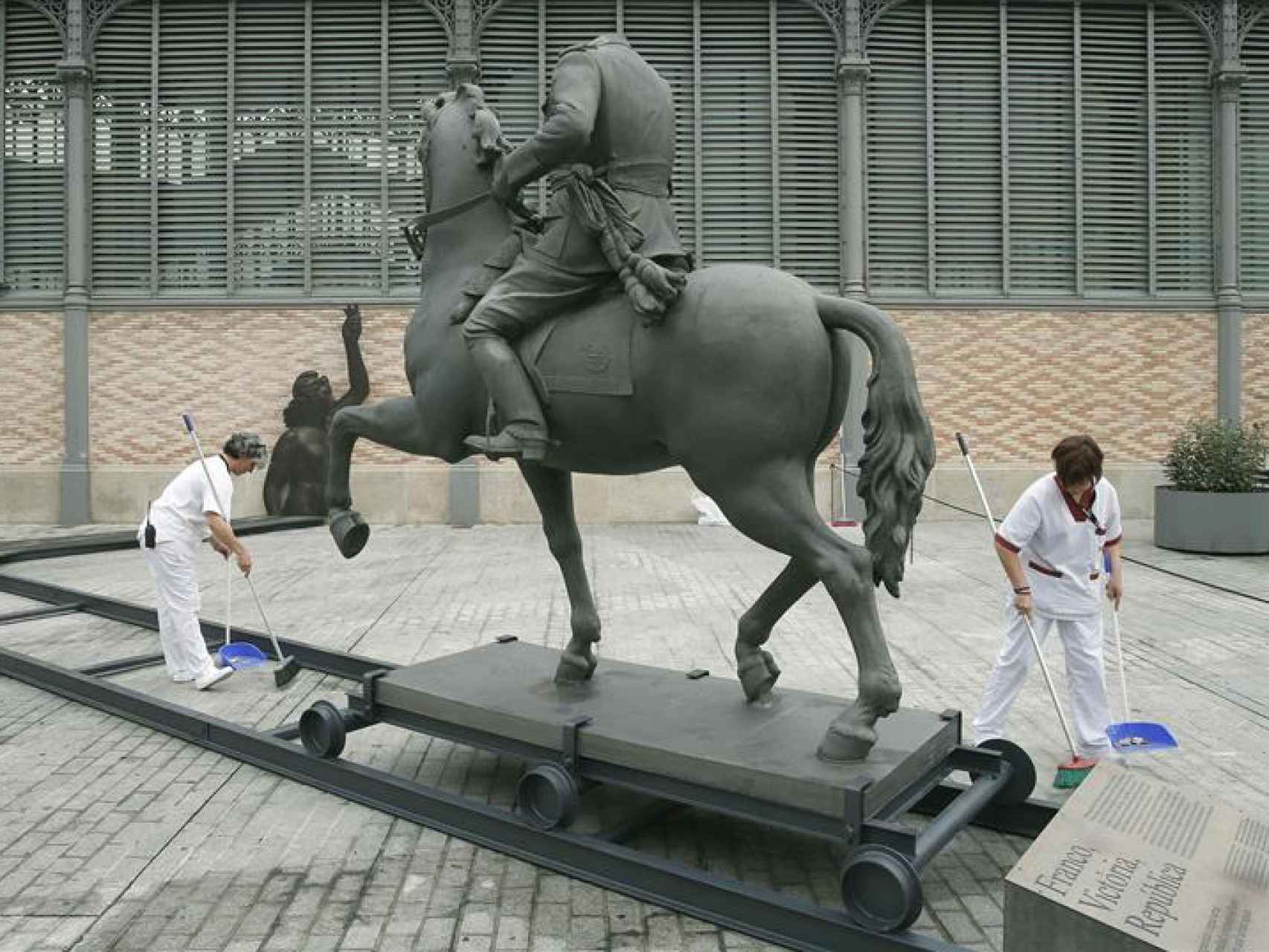 Dos trabajadores instalan la estatua de Franco delante del Born.