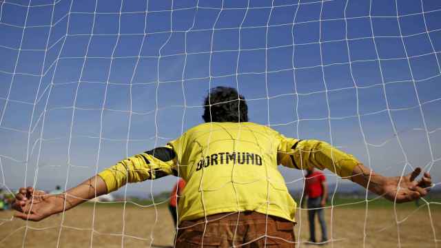 Un refugiado con una camiseta del Borussia Dortmund actúa como portero.