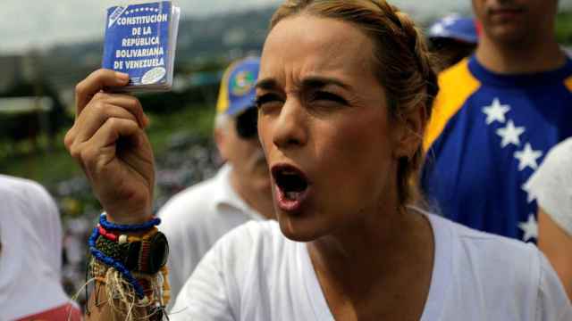 Lilian Tintori muestra un ejemplar de la constitución venezolana, que la oposición denuncia vulnerada.