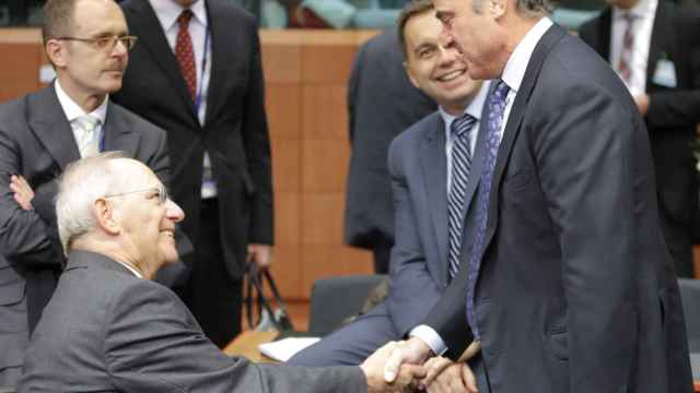 Guindos saluda al ministro alemán Wolfgang Schäuble durante la reunión del Eurogrupo
