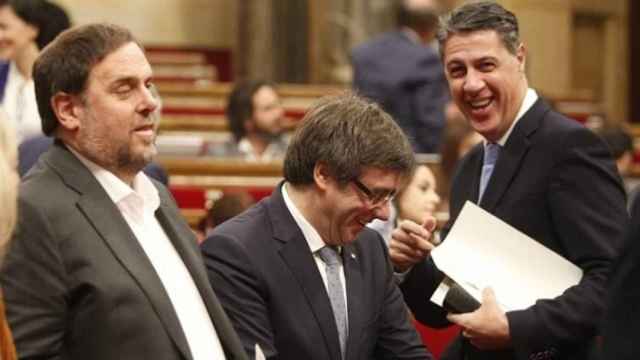 El presidente de la Generalitat, Carles Puigdemont (c) y Oriol Junqueras (i) saludan al líder del PPC, Xavier García Albiol (d).