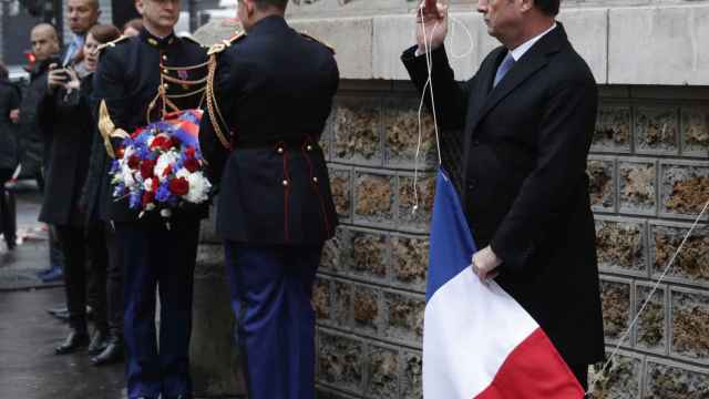 El presidente Francois Hollande destapa una de las placas conmemorativas cercana al café La Belle Equipe.