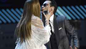 Marc Anthony y Jennifer Lopez sobre el escenario, a punto de darse un beso.