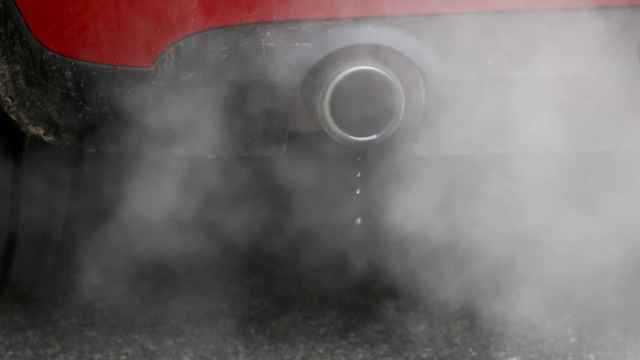 Un coche emite humos por el escape en Richmond, Londres.