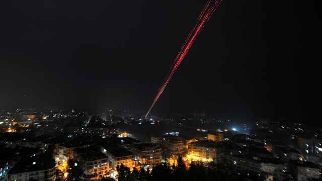 Fuerzas gubernamentales sirias lanzan fuego al aire en Alepo para celebrar su victoria.