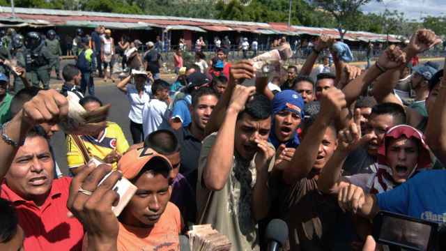 Un grupo de personas protesta en el centro y las inmediaciones del Banco Centra de Venezuela este sábado en la ciudad de Maracaibo.