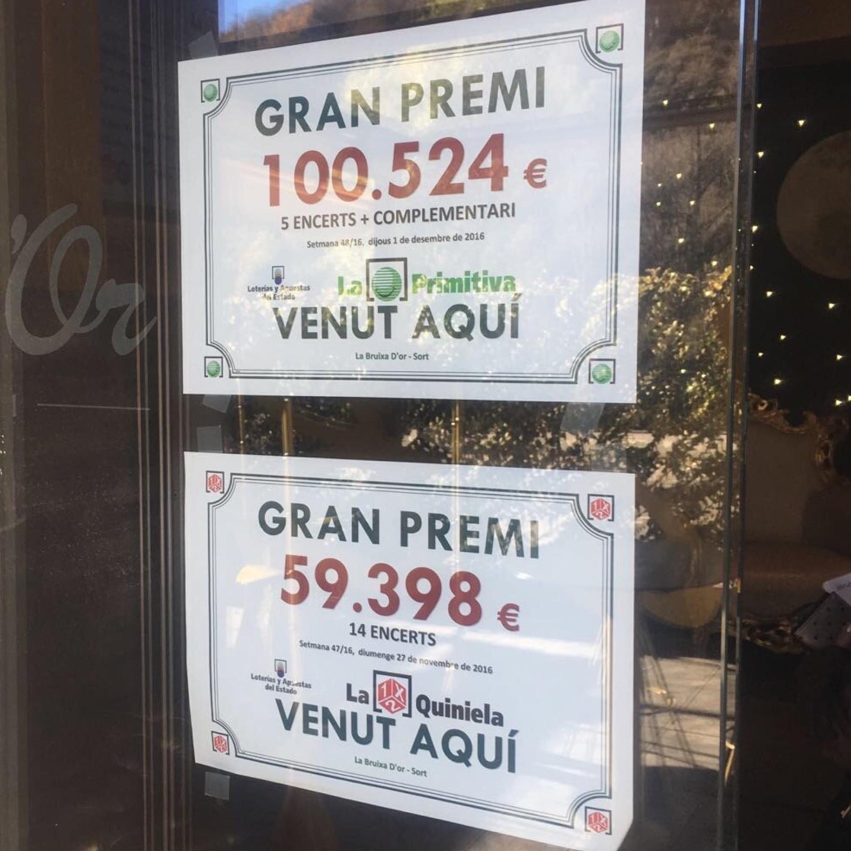 Carteles que anuncian la venta de décimos premiados en la puerta de La Bruixa d'Or