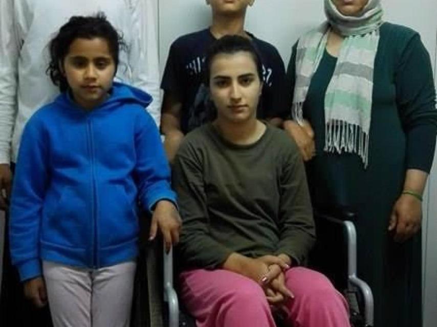 Sahar, que va en silla de ruedas, con su familia en Grecia.