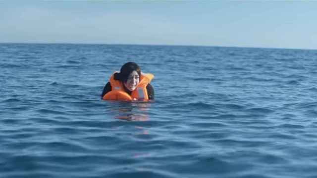 Una mujer refugiada llora en medio del mar.