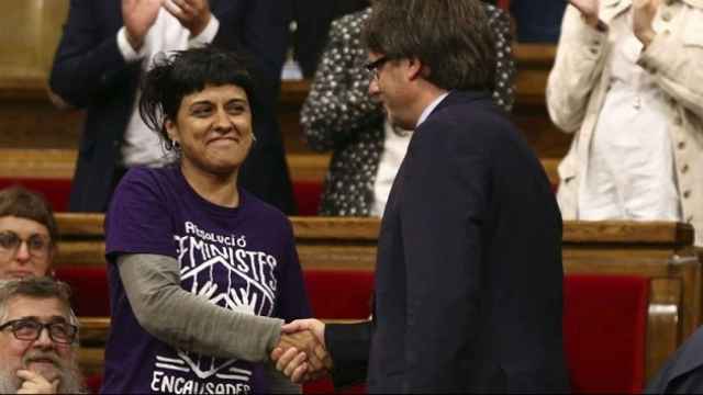 El presidente catalán, Carles Puigdemont, saluda a la diputada de la CUP Anna Gabriel en el 'Parlament'.