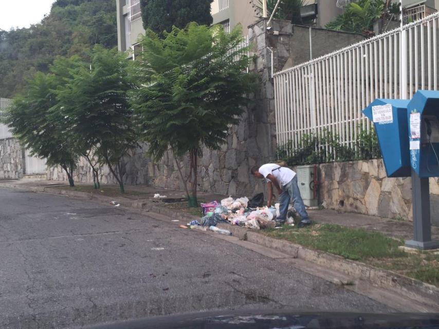 Un hombre buscando comida en la base en Caracas.