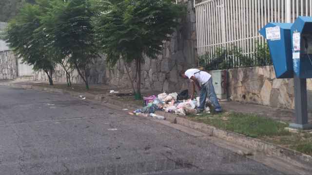 Un hombre buscando comida en la base en Caracas.