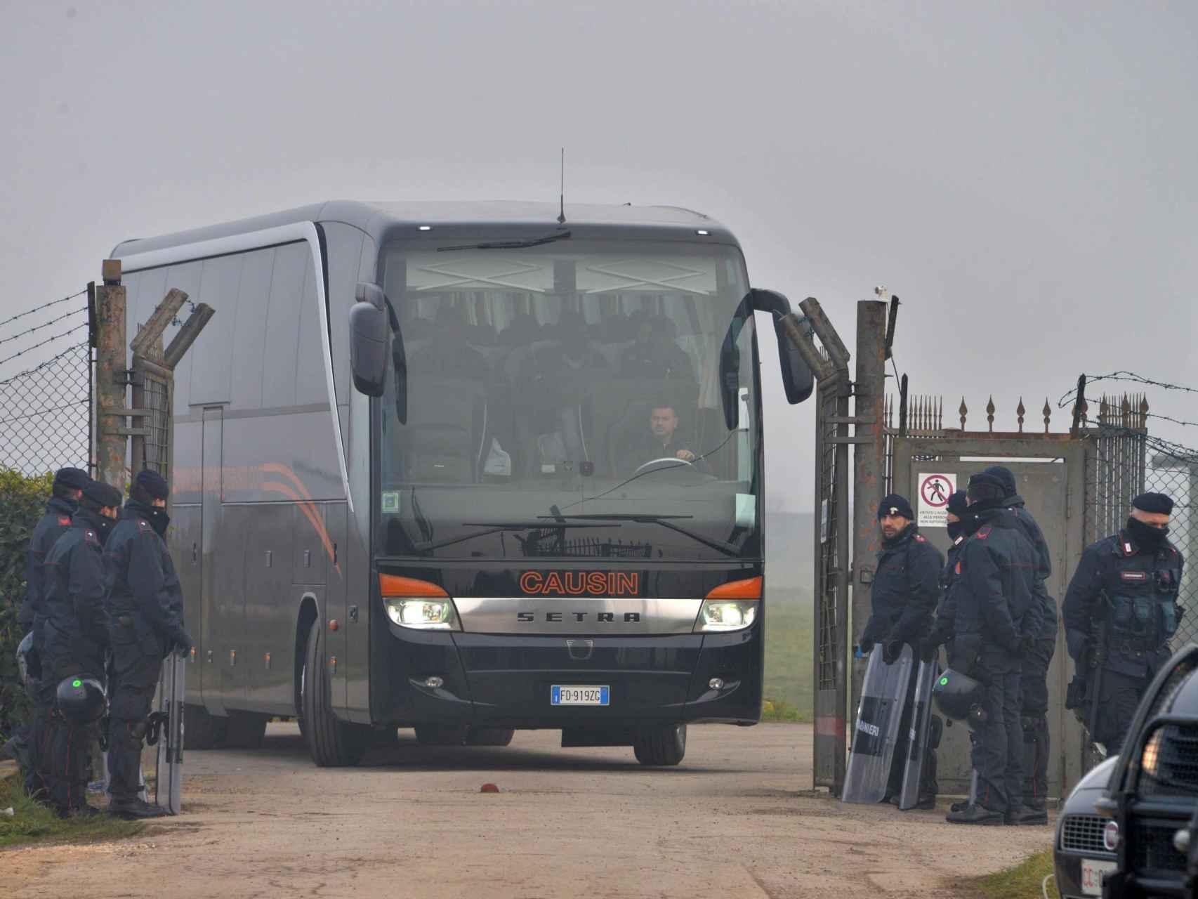 Agentes italianos custodian un autobús que traslada un grupo de migrantes en Cona, Venecia.
