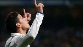 James Rodríguez celebra un gol con el Real Madrid señalando al cielo.