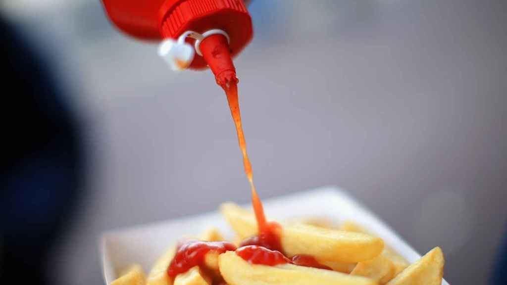 Un aficionado echa ketchup en sus patatas antes de un partido Southampton-Everton.