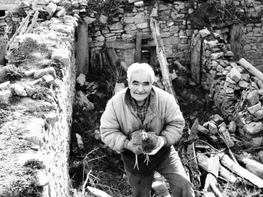 Ángel sale con una gallina de una casa derruida en Bretún (Soria).