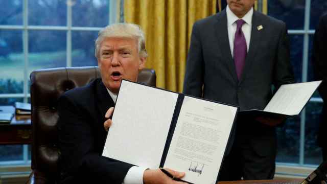Trump muestra su orden ejecutiva para sacar a EEUU del TPP.