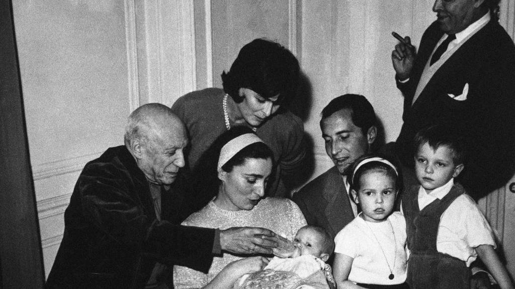 Pablo Picasso, a la izquierda, dándole el biberón a su ahijada, Paola Dominguín, en su bautizo en Cannes junto al resto de la familia.