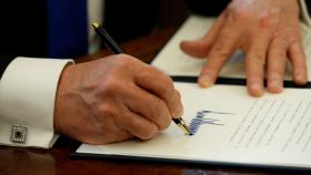 U.S. President Donald Trump signs an executive order at the White House in Washington