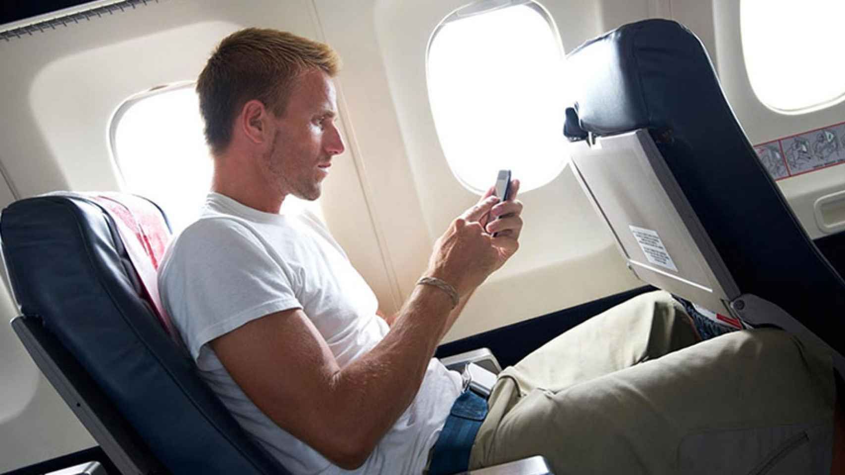 Телефон во время полета в самолете. Самолет с пассажиром. Мужчина в самолете. Мужчина сидит в самолете. Парень в самолете.