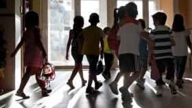 Un grupo de niños saliendo de un centro escolar.