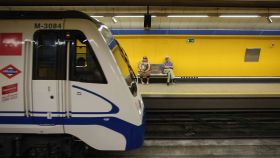 Dos pasajeros esperan al metro en una estación madrileña.