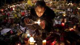 Una niña enciende una vela en tributo a las víctimas de los atentados de Bruselas en marzo de 2016.