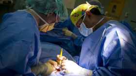 Dos médicos realizando una operación quirúrgica a un paciente.
