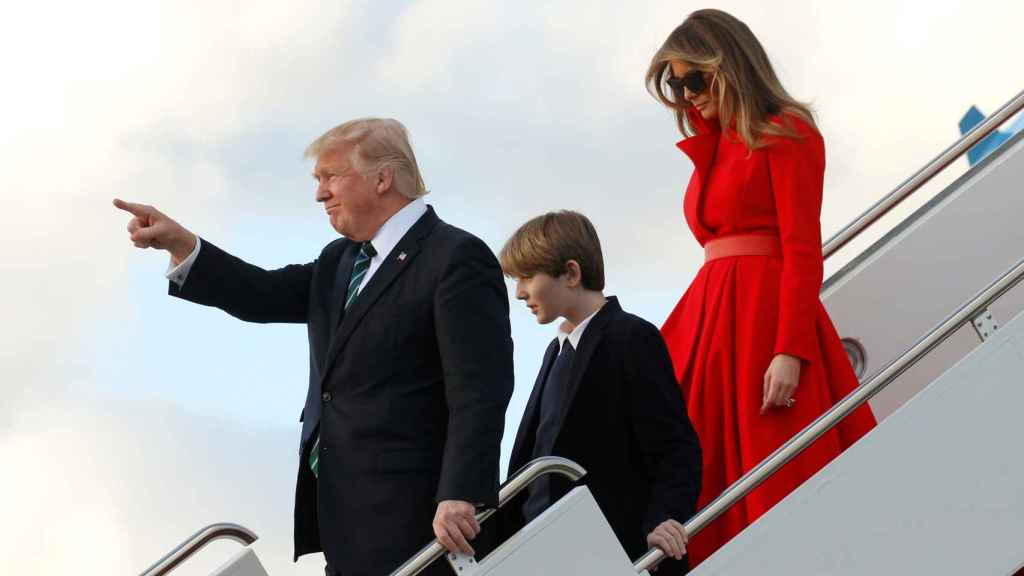 Trump, junto a su hijo Barron y a su mujer Melania, este sábado tras aterrizar en Florida.