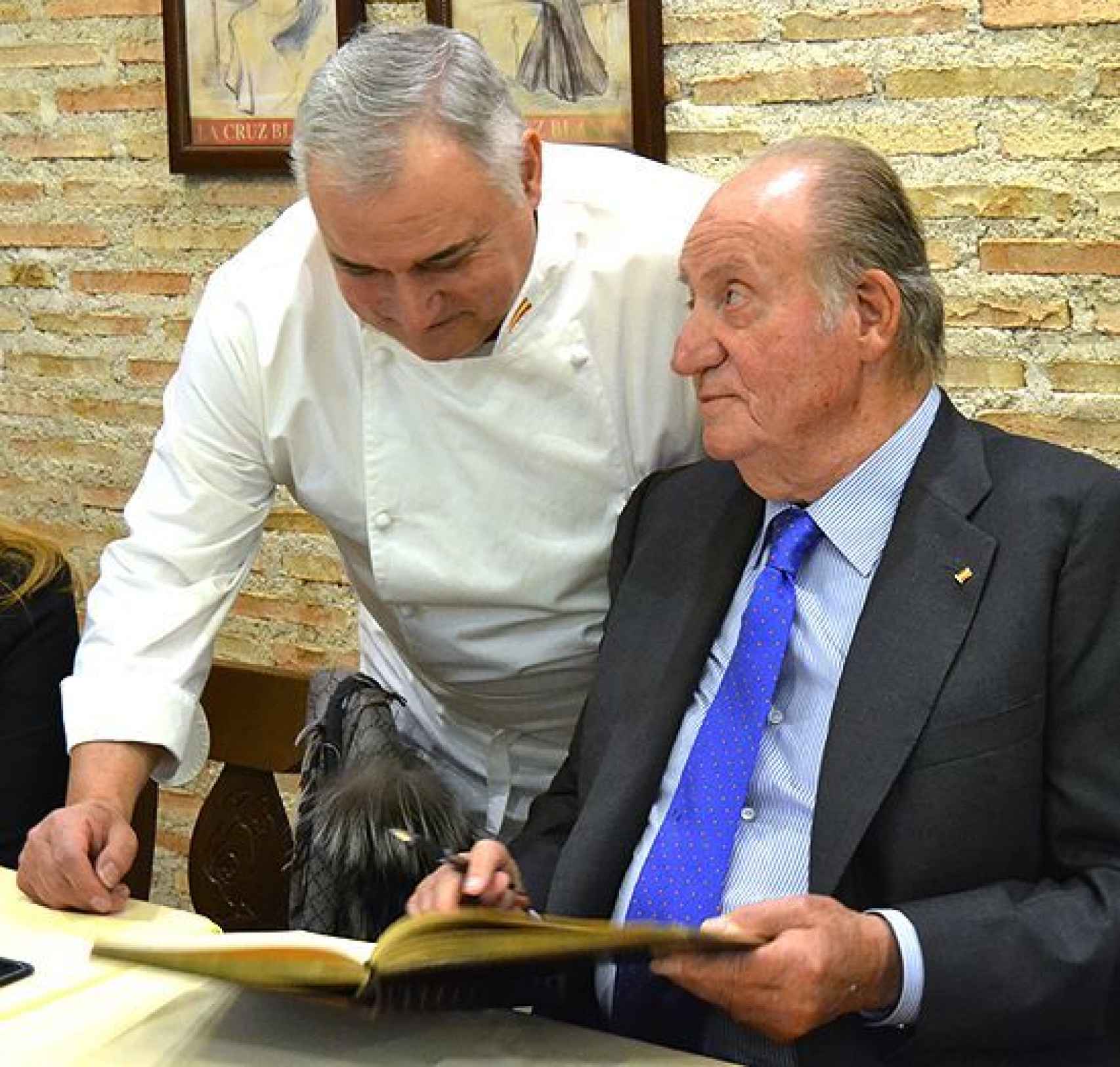El rey Juan Carlos firma en el libro de honor ante la presencia de Antonio Cosmen.
