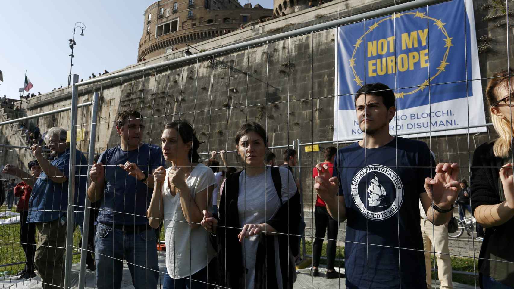 Varios manifestantes, ante el Castillo Sant'Angelo, protestan por las políticas europeas de frontera.