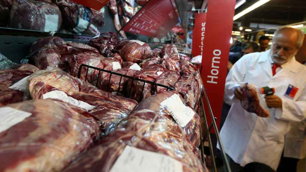 Un funcionario del Ministerio de Salud chileno revisa la carne brasileña en los estantes de un supermercado en Santiago de Chile.