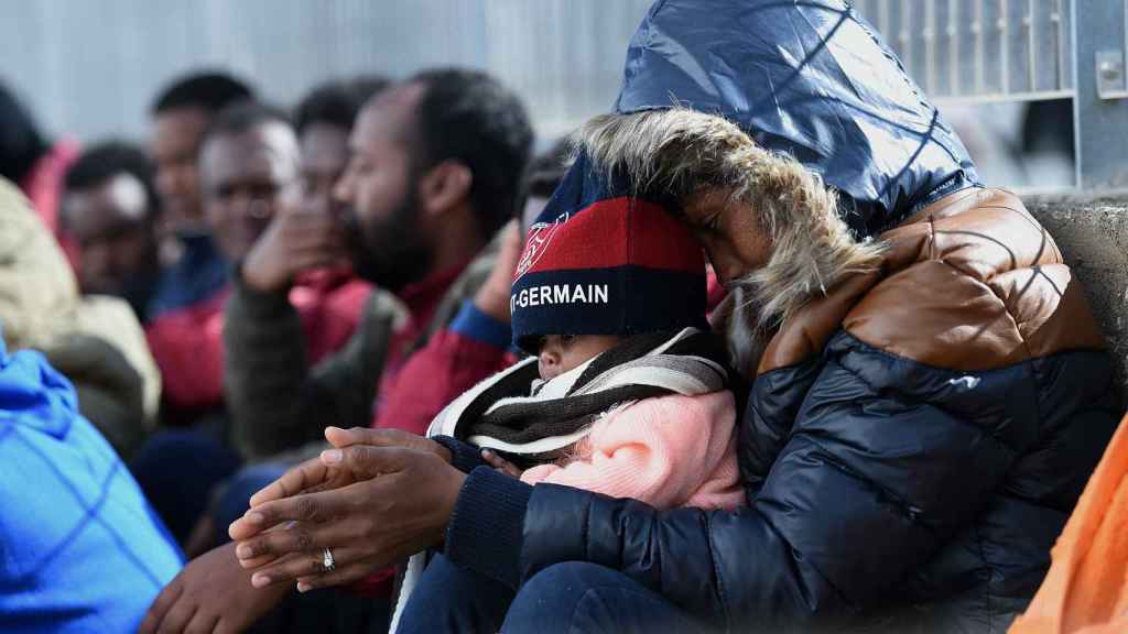 Un grupo de inmigrantes espera a un barco en el puerto de Lampedusa en una imagen del verano de 2015
