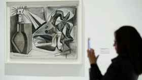 Una visitante frente a la obra de Picasso Cráneo de cabra, botella y vela, en el Museo Reina Sofía.